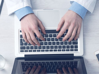 Hands typing on laptop keyboard